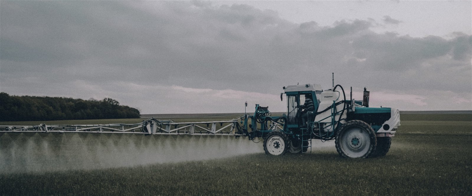 A tractor spraying water on a field 